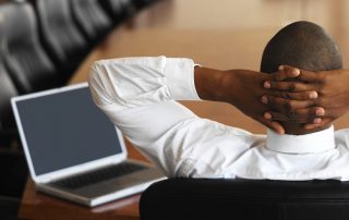 businessman relaxing in an empty conference room with a laptop in front of him