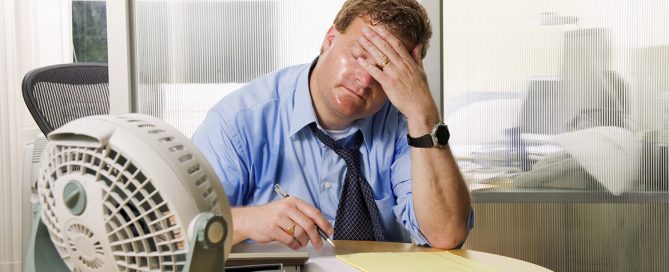 Fan blowing on a businessman