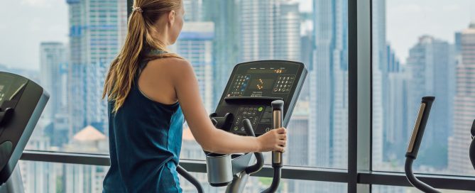 Woman exercising on an elliptical in a multi-family building